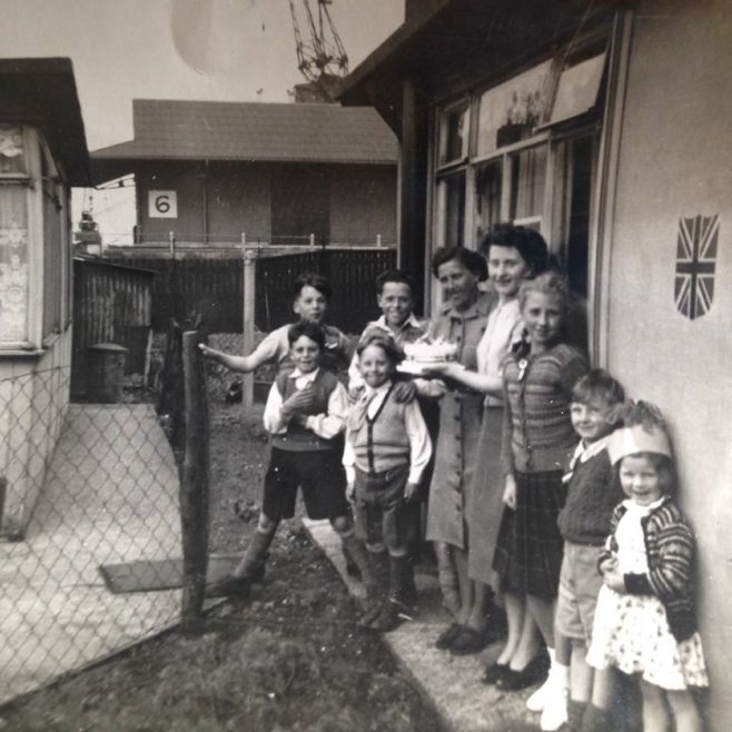 Family group outside a prefab decorated for the coronation, Albert Road, North Woolwich | Hearn, Jane