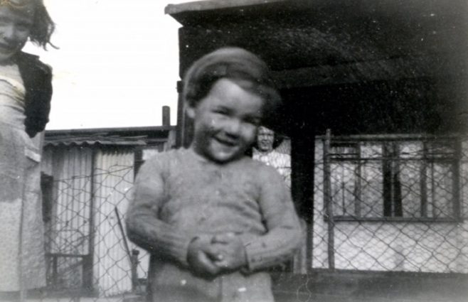 Two children, a girl and a boy, outside a prefab in Underhill Road, London SE22